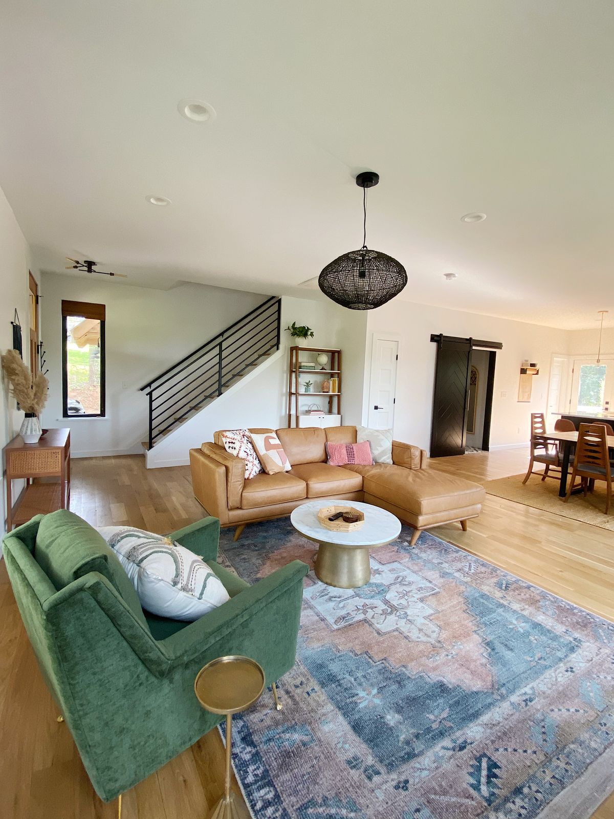 Living room with a leather sectional, open to the dining area.